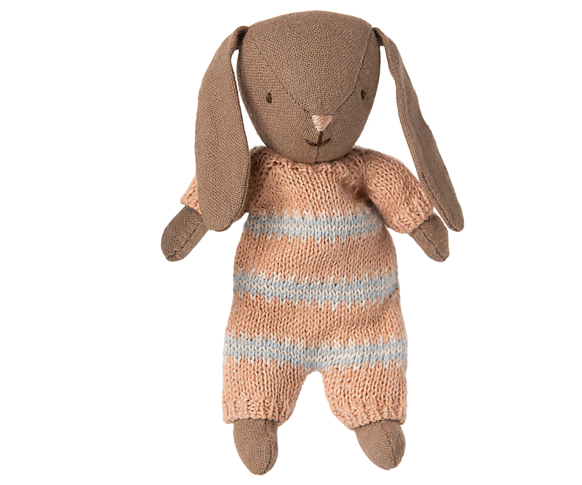 Brown stuffed bunny toy in pink and white striped playsuit against a white background
