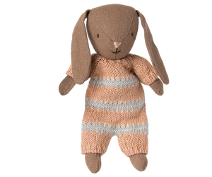 Brown stuffed bunny toy in pink and white striped playsuit against a white background