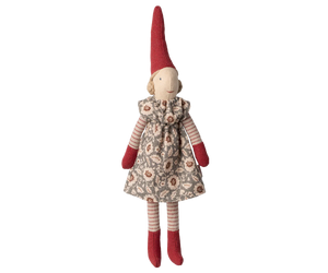 Stuffed pixy toy with a red hat and floral dress on a white background