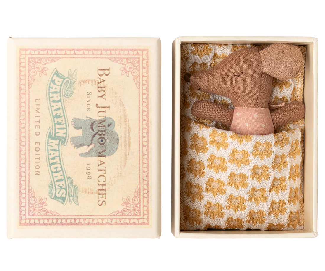 Small brown mouse in a decorative box with a floral patterned blanket