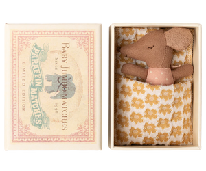 Small brown mouse in a decorative box with a floral patterned blanket