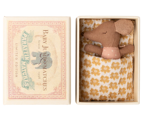 Small brown mouse in a decorative box with a floral patterned blanket