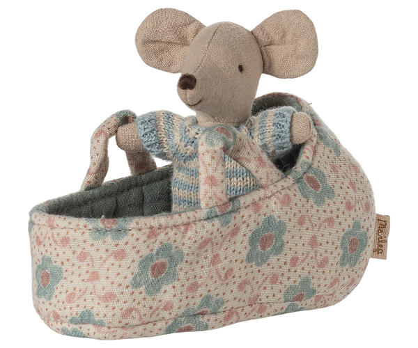 Stuffed mouse toy in a floral baby crib on a white background