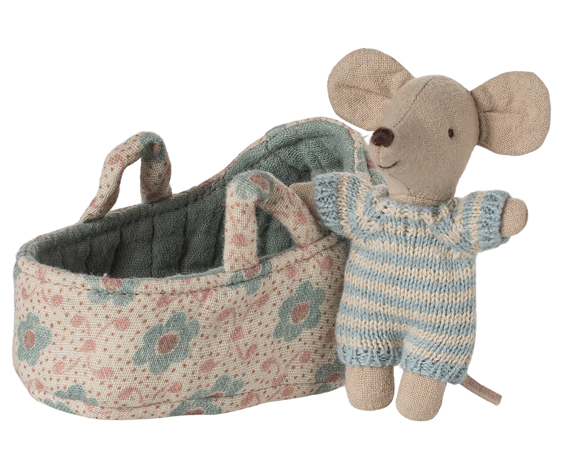 Toy mouse next to a floral-patterned carry cot on a white background