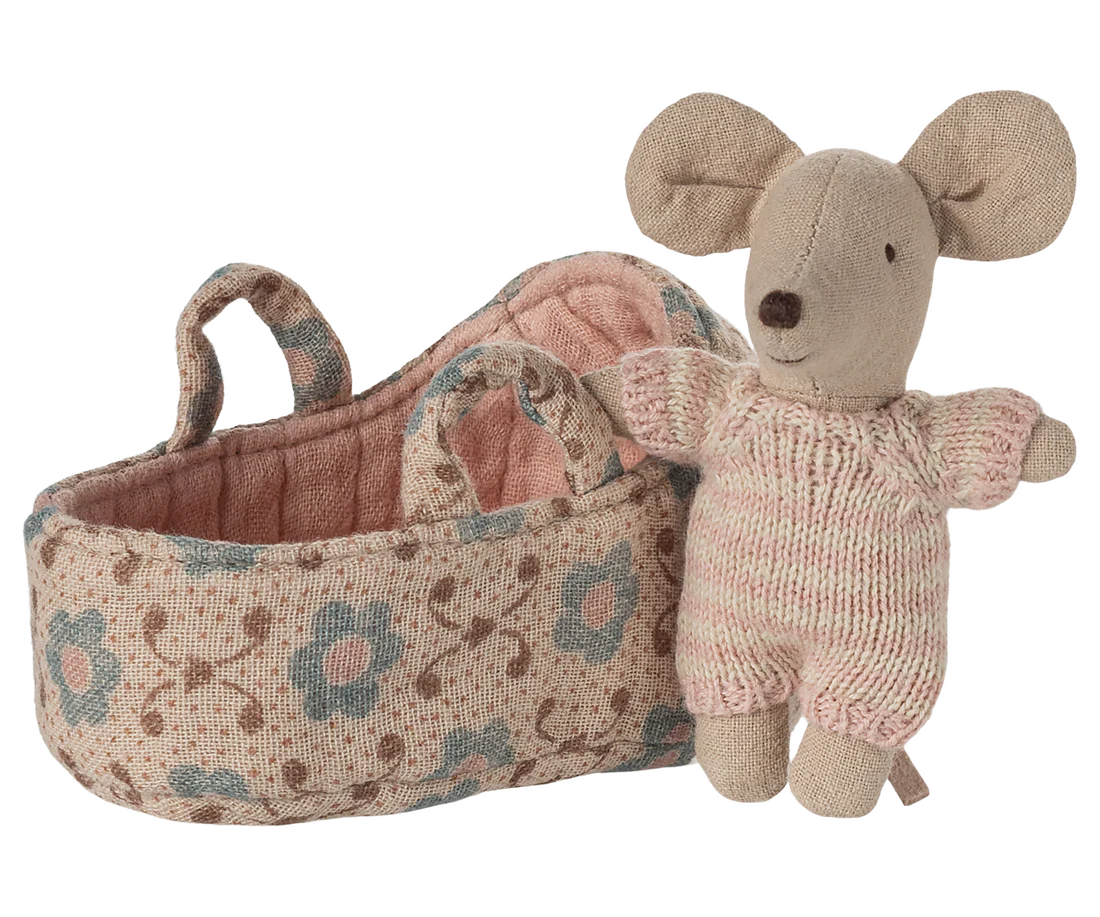 Mouse toy in a knitted outfit next to a  floral-patterned basket on a white background