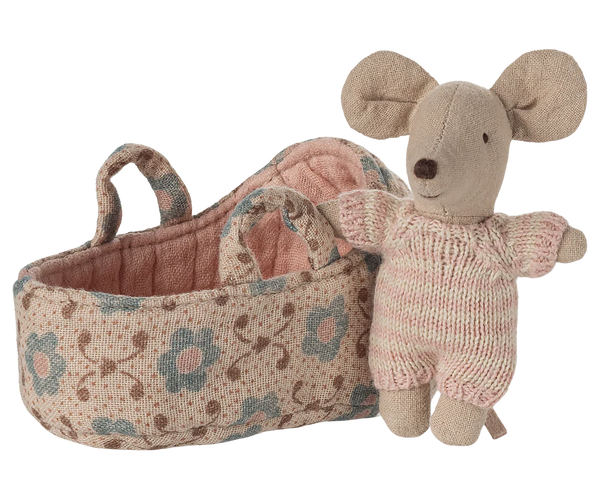 Mouse toy in a knitted outfit next to a  floral-patterned basket on a white background