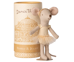 Stuffed mouse doll in a tutu dress next to a cylindrical box with decorative design and text.
