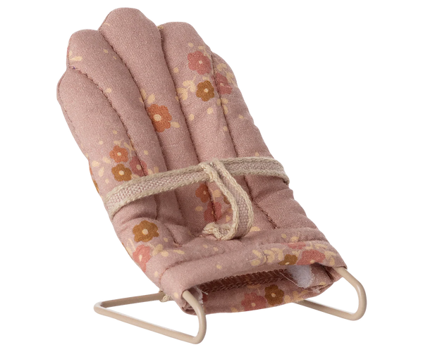 Pink floral babysitter for seating a toy baby rabbit on a white background