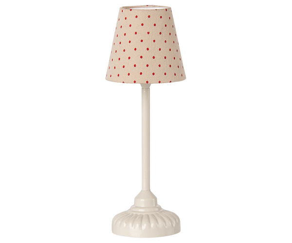 Small floor lamp with a beige lampshade featuring red polka dots on a white background