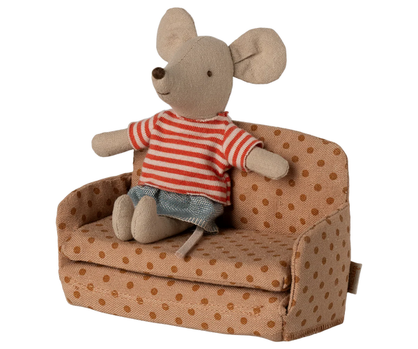 Stuffed mouse toy in a striped shirt sitting on a polka dot couch with a white background