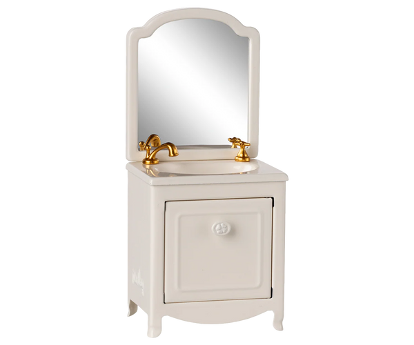 White vanity with mirror and gold fixtures on a white background