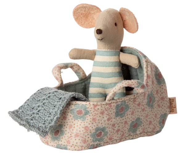 Stuffed mouse toy in a floral baby cot with a blue blanket on a white background