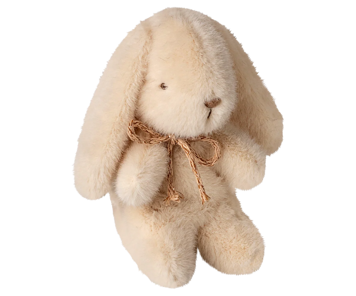 Cream plush bunny with a brown bow on a white background