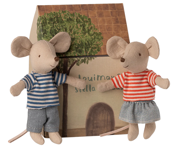 Two toy mice in front of a cardboard house with a tree illustration.
