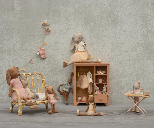 Miniature toy set with teddy bears in a room setting on a wooden floor.