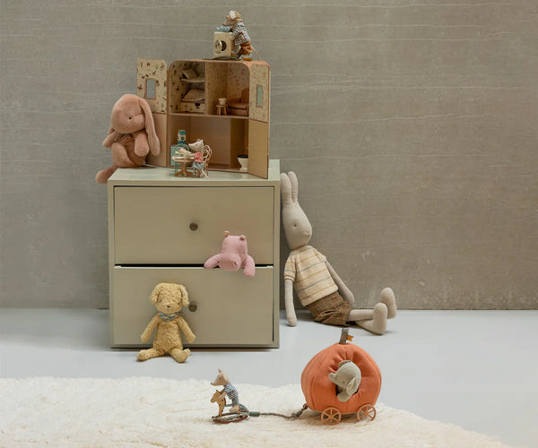 Soft toy bunnies, mice and a hippo on a small chest of draws