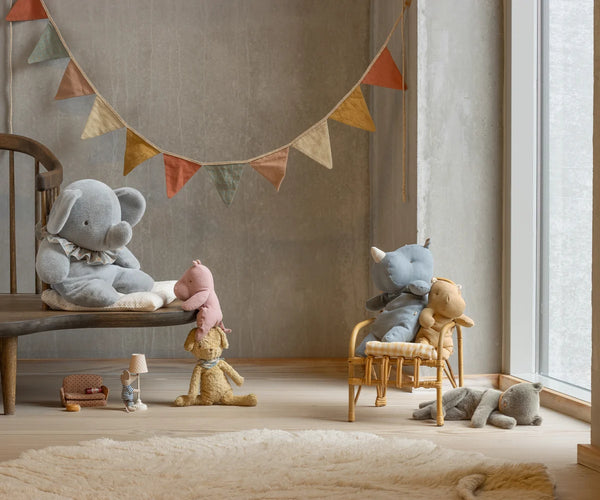 Children's room with plush toys and a colourful banner on a wall.
