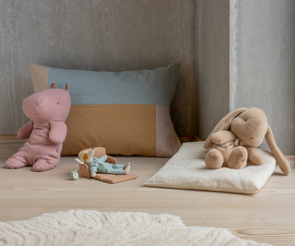 Soft toys and a cushion on a wooden floor
