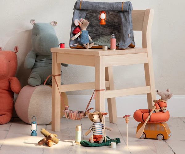 Wooden chair with toys and decorative items on a light-colored floor.