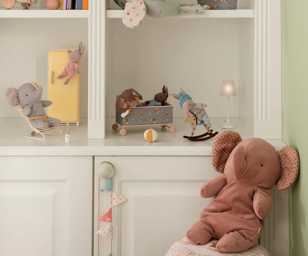 Soft toys in playful poses on a white shelf display