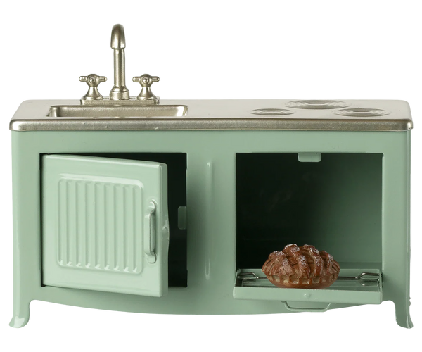 Miniature green kitchen set with sink and stove on a white background