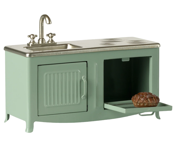 Green toy kitchen set with sink and stove on a white background