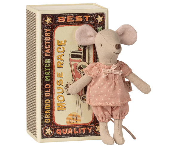 Stuffed mouse toy standing in front of a decorative box with text