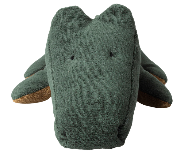 Green plush crocodile toy with a face on a white background