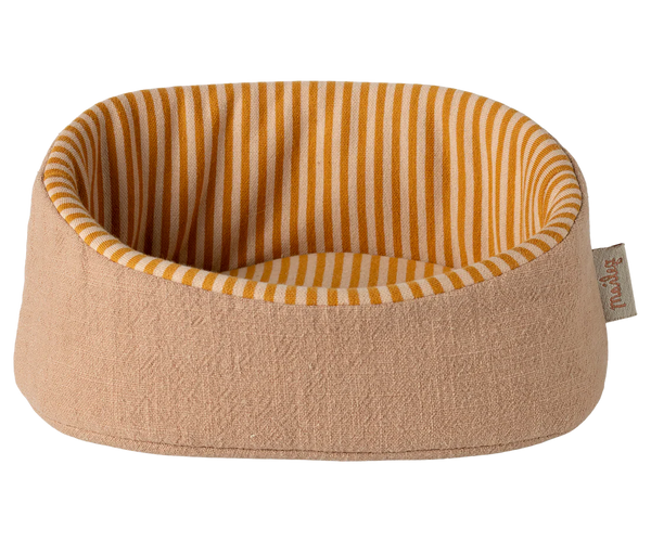 Dog bed with striped interior and pink 
exterior on a white background
