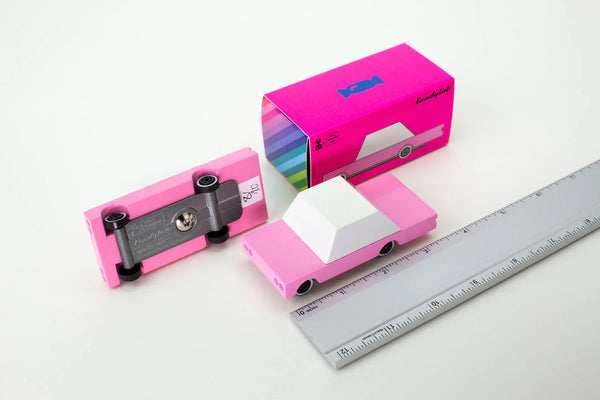 Pink toy cars and packaging on a white background with a ruler to show the size