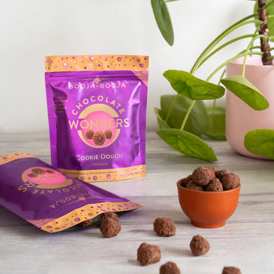 Booja-Booja Chocolate Wonders cookie dough packaging with treats on a wooden surface.