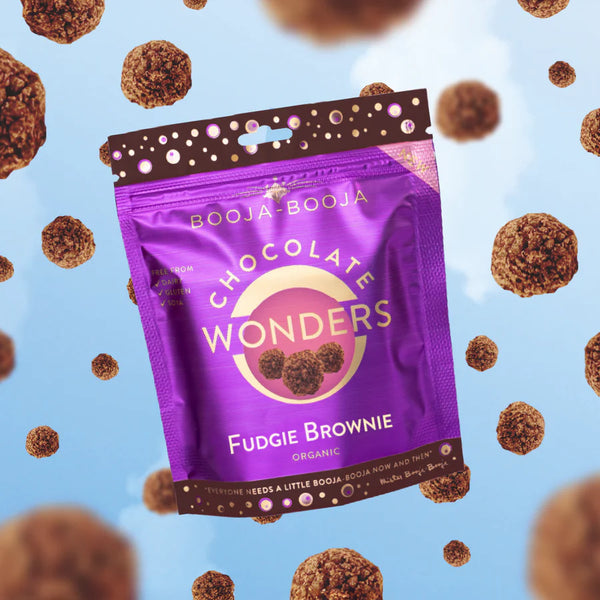 Purple package of Booja-Booja Chocolate Wonders Fudgie Brownie on a blue background with brown treats.