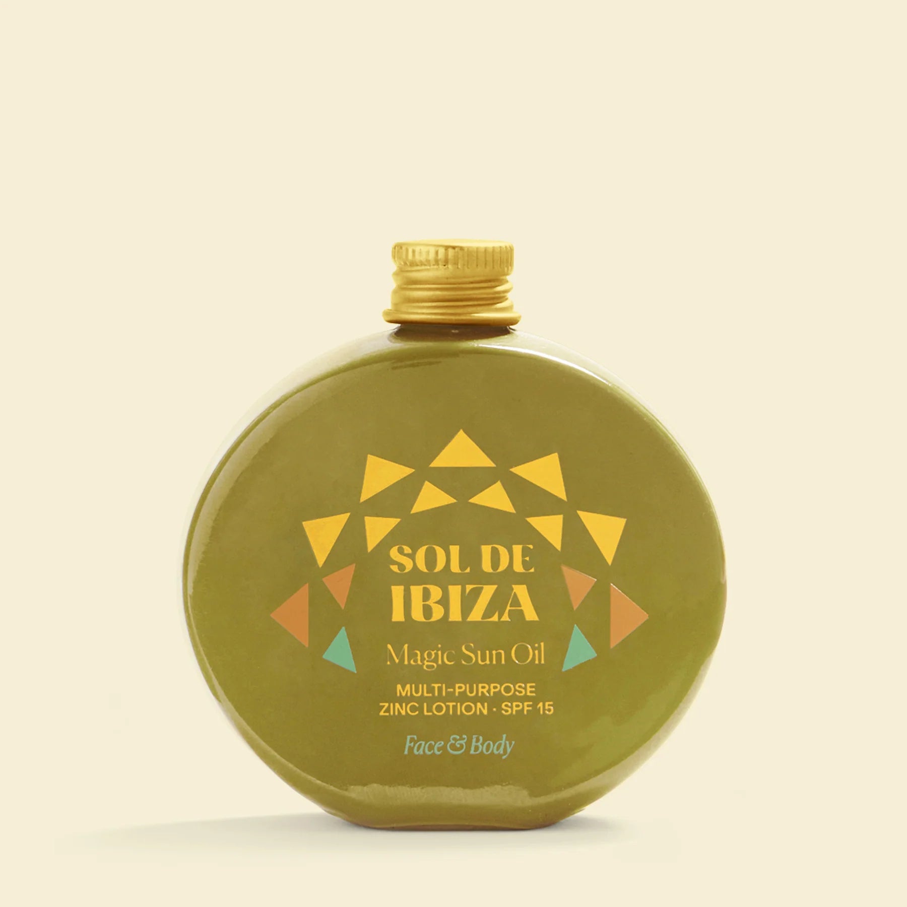 Green bottle of Sol de Ibiza Magic Sun Oil with gold cap on a beige background