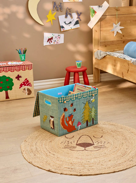 Children's room with a storage box featuring animal illustrations on a wooden floor.