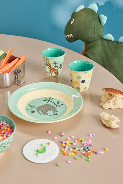 Children's table setting with plates, cups, and snacks on a blue background
