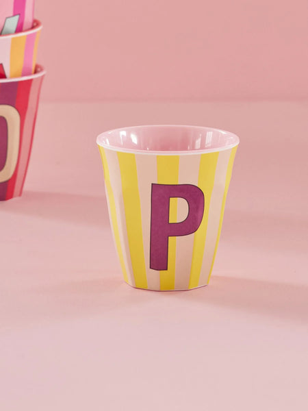 Yellow and pink striped cup with letter 'P' on a pink background