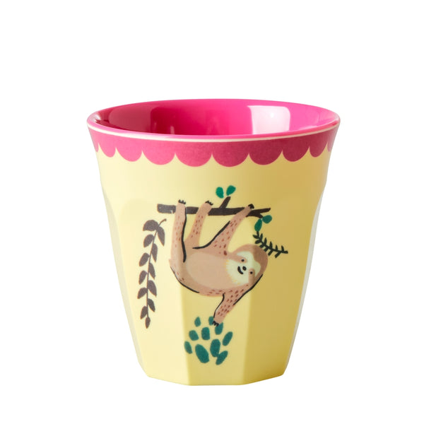 Yellow cup with pink interior, sloth design, and leaf elements on a white background