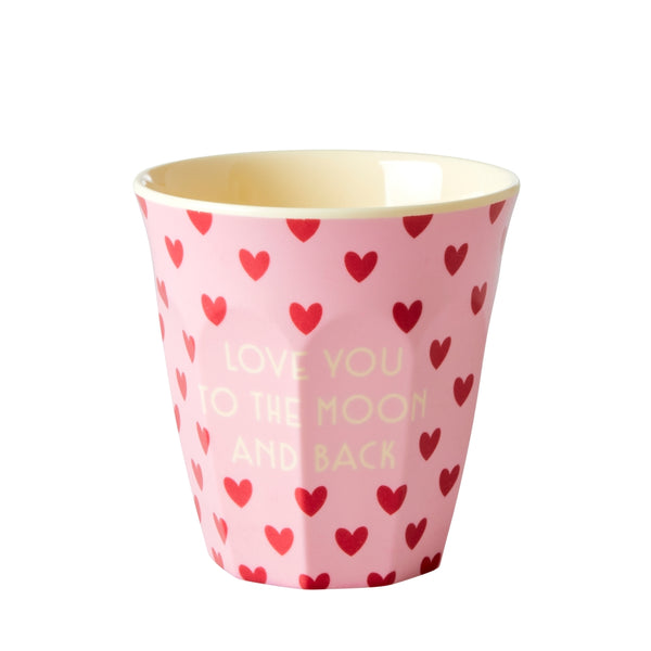 Pink cup with red heart patterns and 'Love You to the Moon and Back' text on a white background