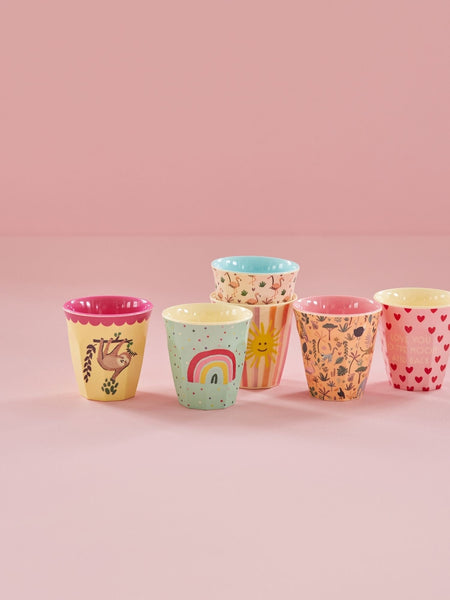Set of colourful patterned cups on a pink background