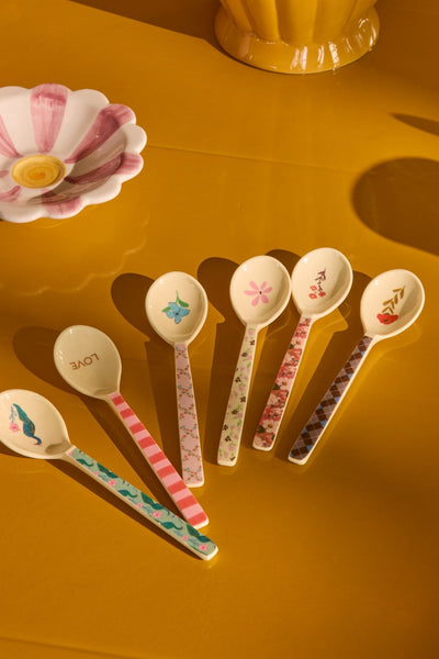 Set of decorative spoons on a yellow surface
