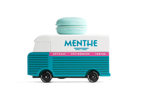 Toy van with a macaron on top, resembling a ice cream truck, on a white background