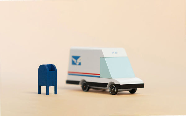 Model of a mail truck and mailbox on a beige background