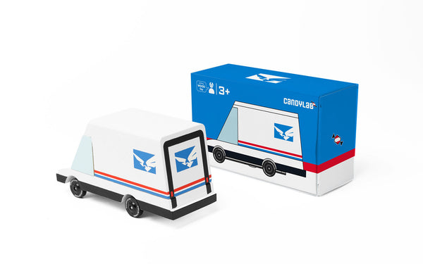 Toy mail truck with CanPost logo next to its packaging box on a white background