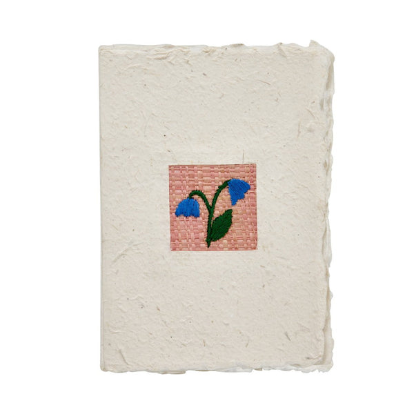 Handmade greeting card with a woven flower design on a white background