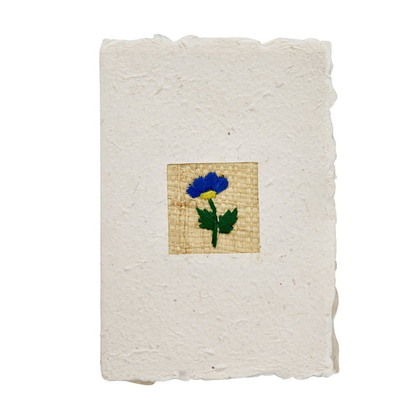 Handmade greeting card with a woven flower design on a white background