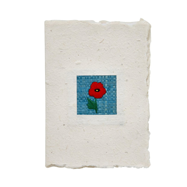 Handmade greeting card with a woven flower design on a white background