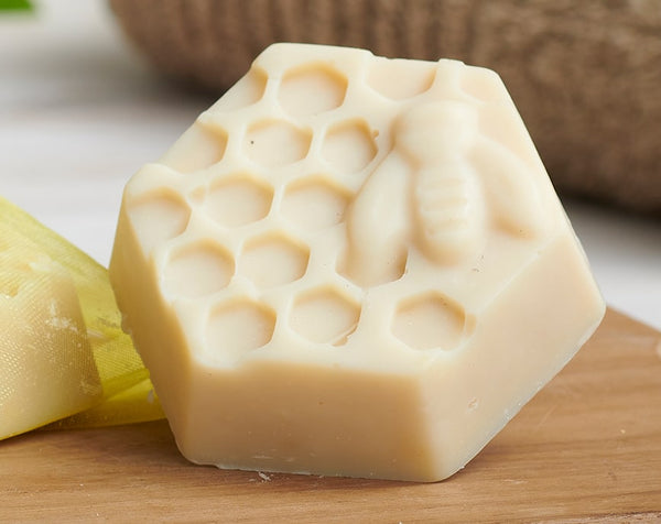 Hexagonal bar of soap with honeycomb pattern on a wooden surface