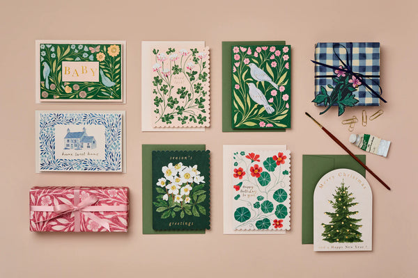 Collection of decorative greeting cards and gift wrap on a beige background