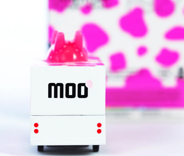 Small wooden van with 'MOO' branding on a pink and white background