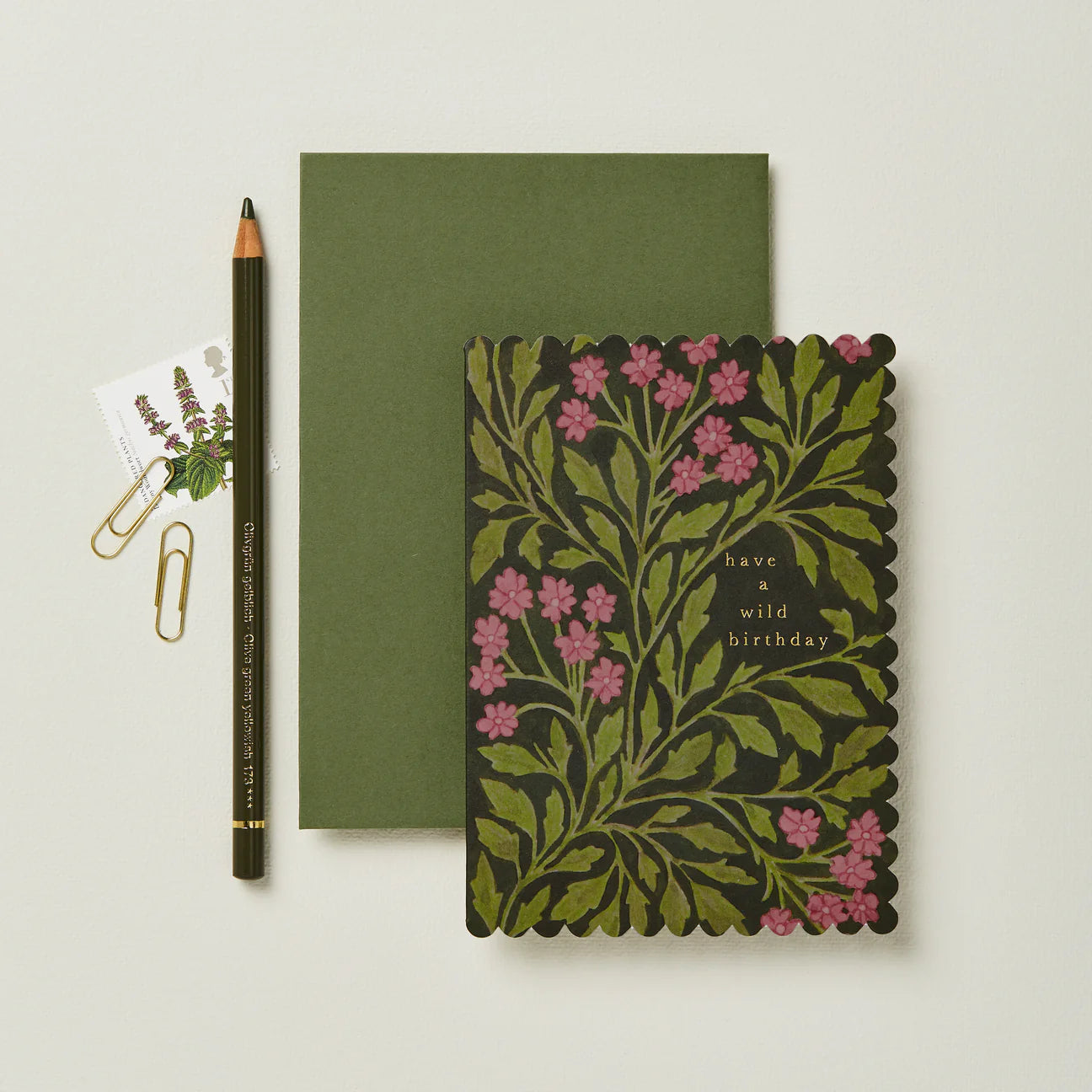 Green notebook with floral design and pencil on a light background